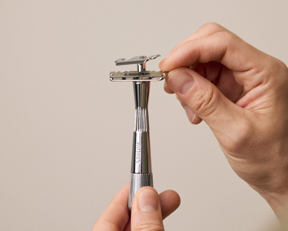 User installs a blade into an open single edge razor