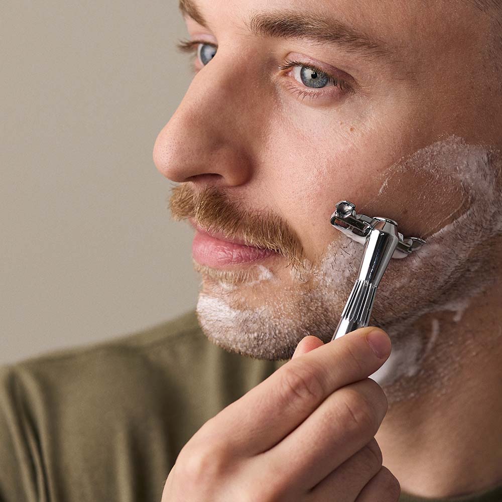 Man uses the single edge razor on his beard