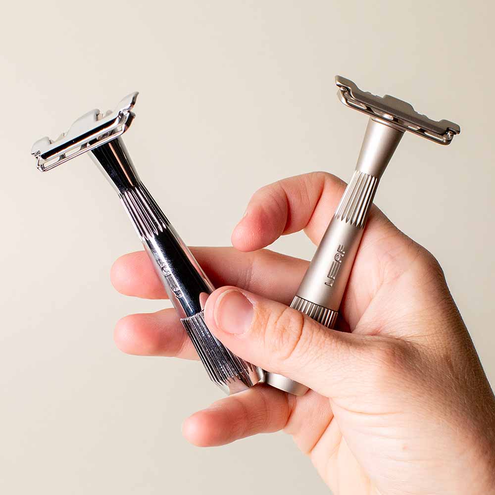 Person holds two single edge razors in one hand