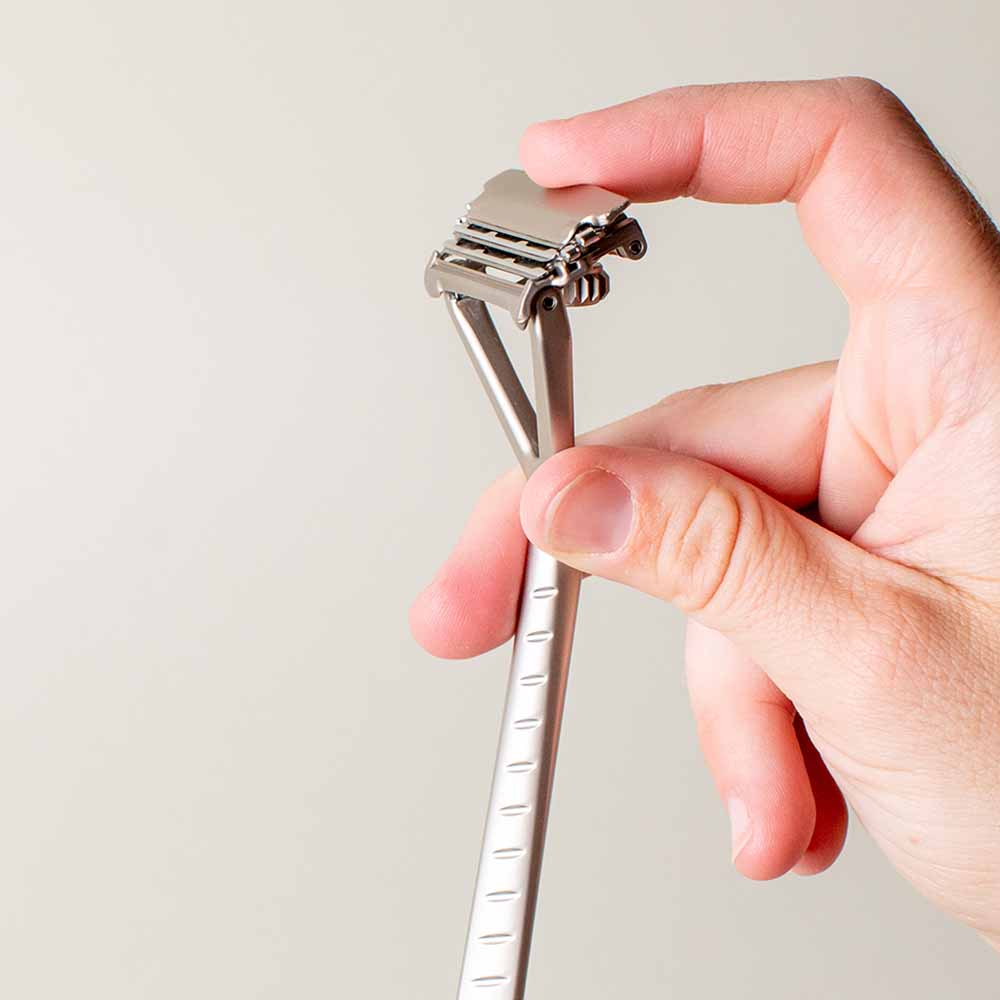 Person pushes back on the head of the leaf razor