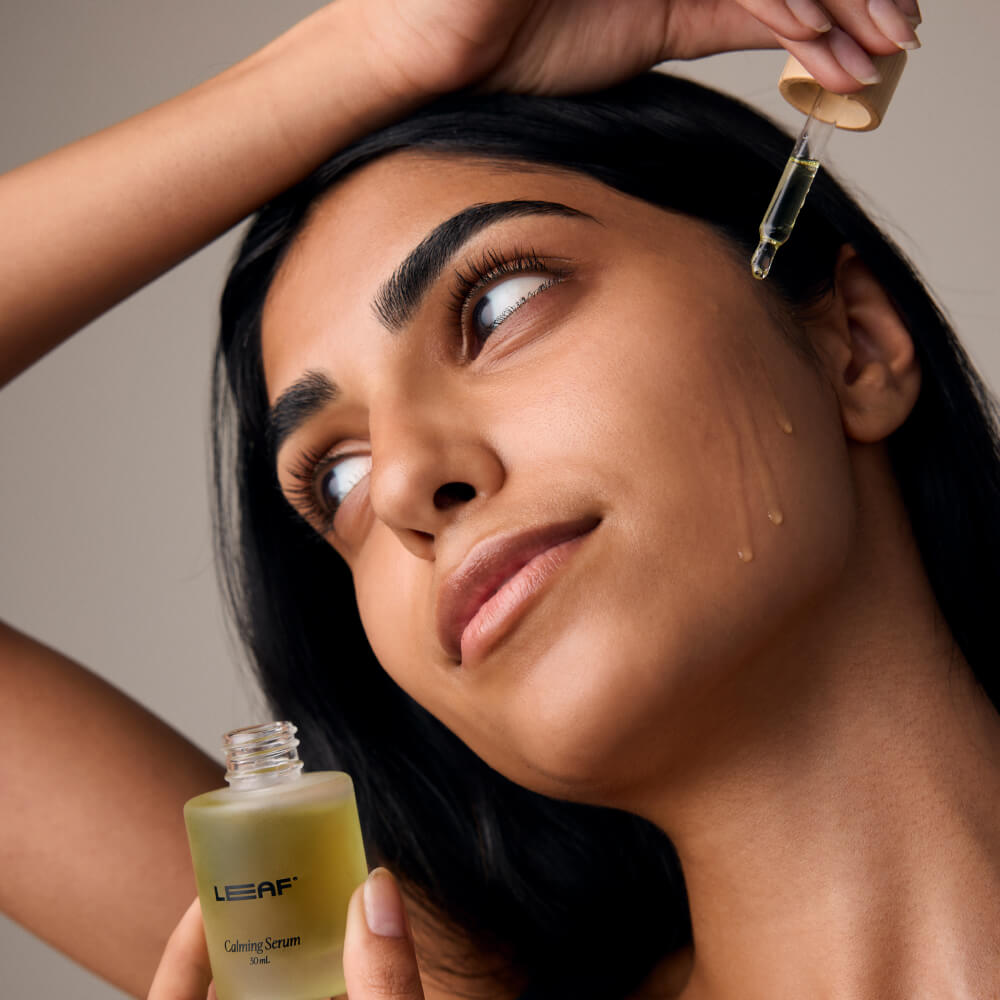 Woman applies calming serum to her cheek