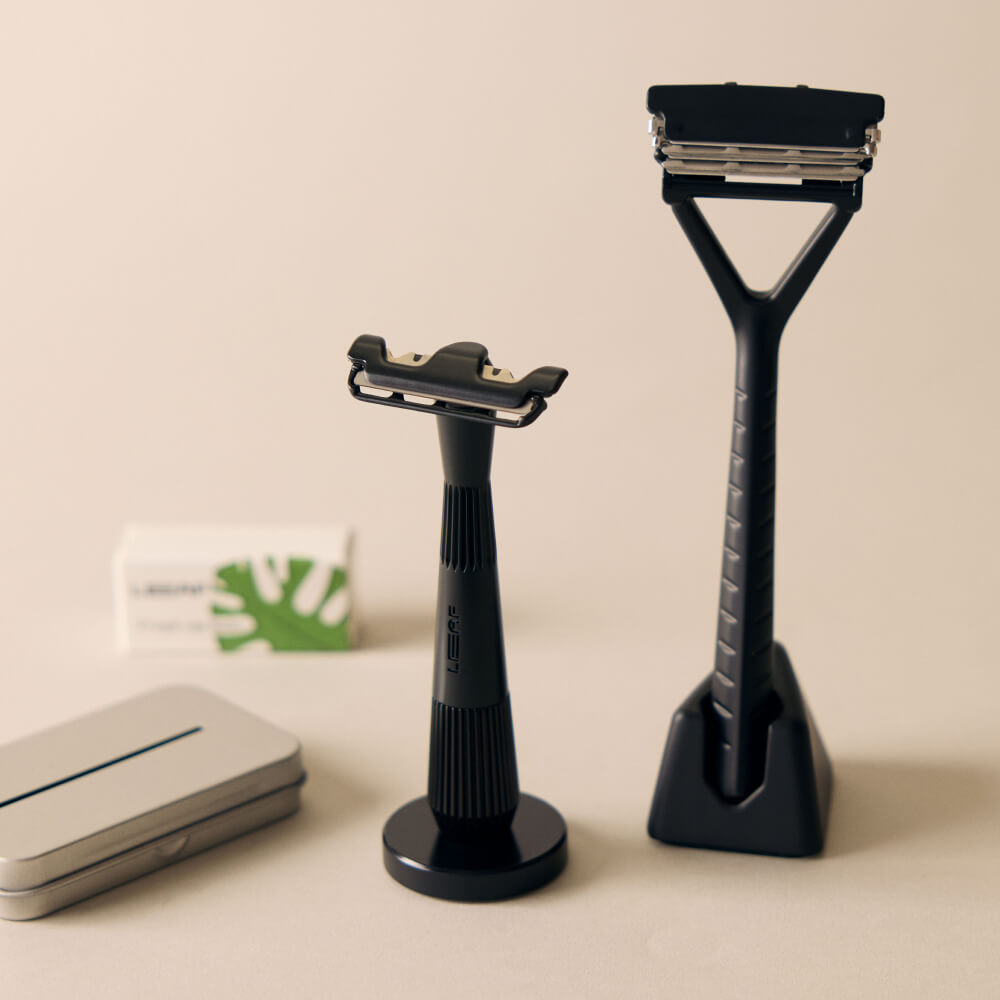 A black razor set kit with a black and single edge razors, blades, and recycling tin