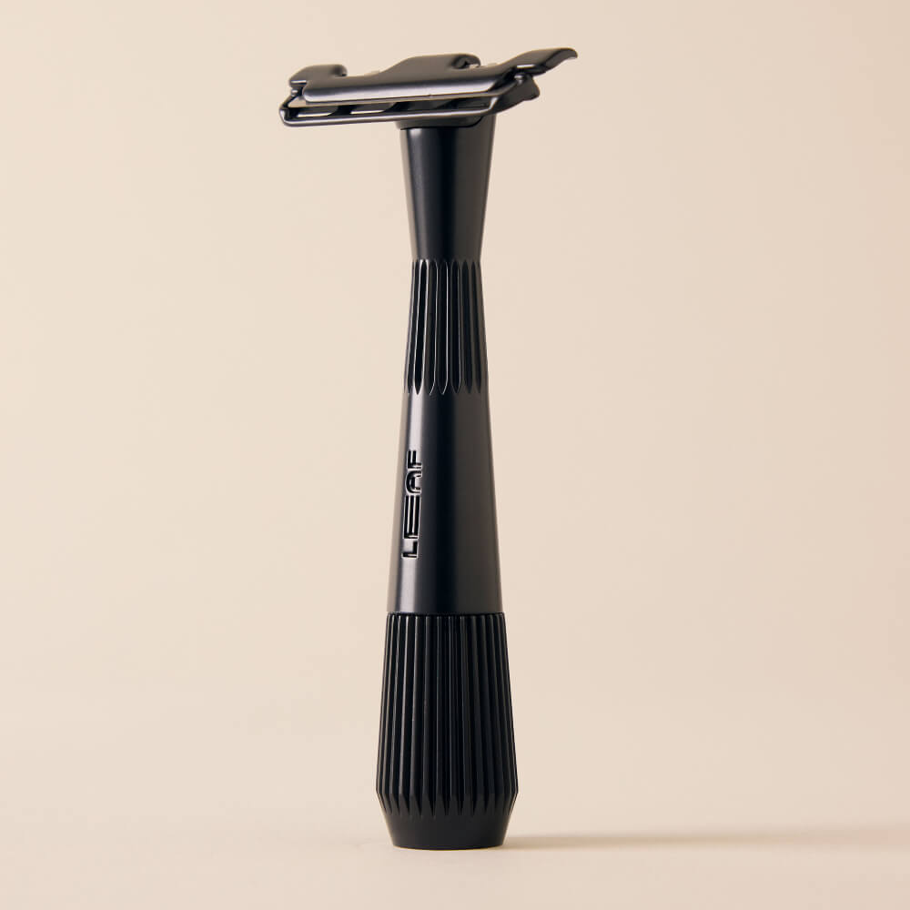 Black single edge razor standing by itself