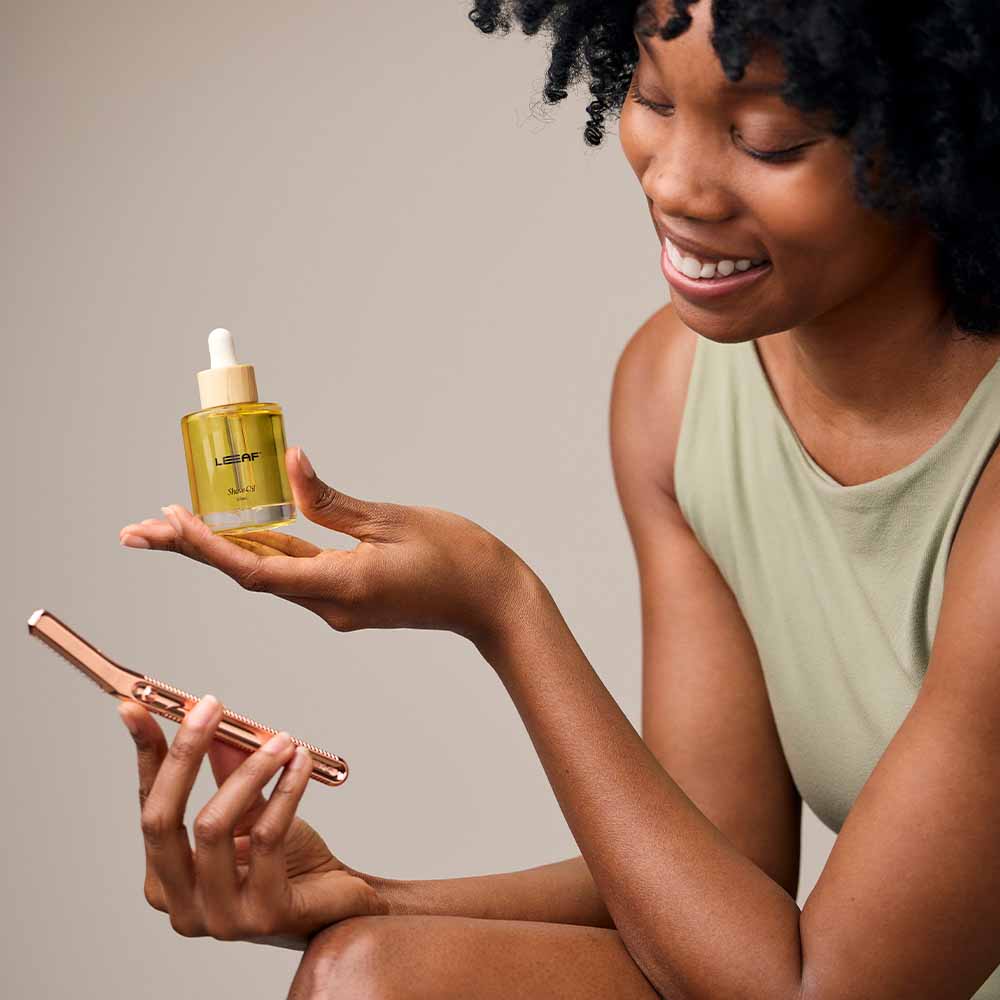 Woman holds the dermaplaner and shave oil