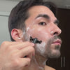 Man shaves his facial area on each side